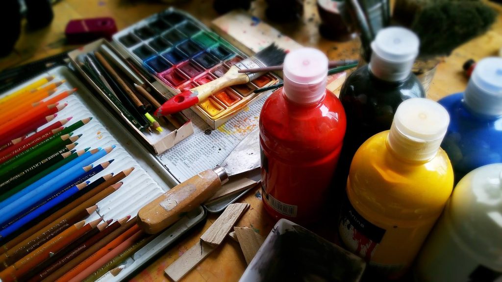 Una imagen con un surtido de pinceles y vibrantes colores de pintura, que representa las herramientas de un artista y el potencial de la creatividad y la expresión artística.